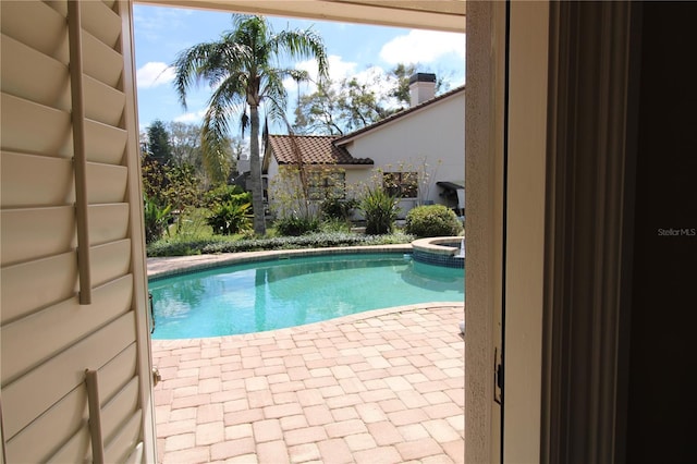 view of pool featuring a patio area and a pool with connected hot tub