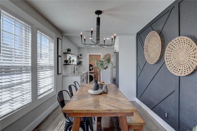 315 40th St S, Saint Petersburg, FL 33711 - dining space featuring light wood-type flooring, washer / clothes dryer, a notable chandelier, and a textured ceiling