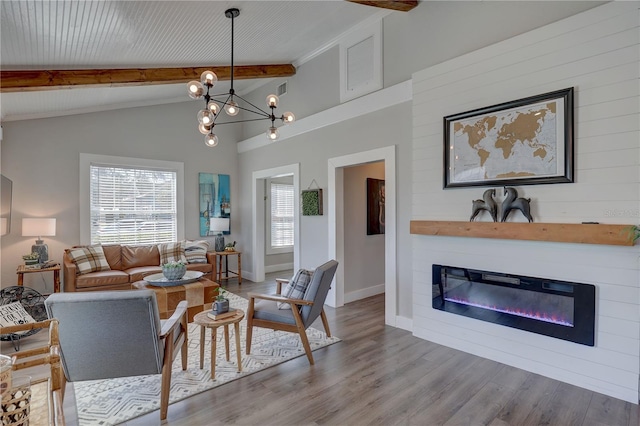 315 40th St S, Saint Petersburg, FL 33711 - living room with baseboards, a glass covered fireplace, lofted ceiling with beams, wood finished floors, and an inviting chandelier