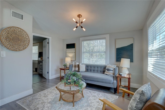 315 40th St S, Saint Petersburg, FL 33711 - living room with an inviting chandelier, plenty of natural light, visible vents, and wood finished floors