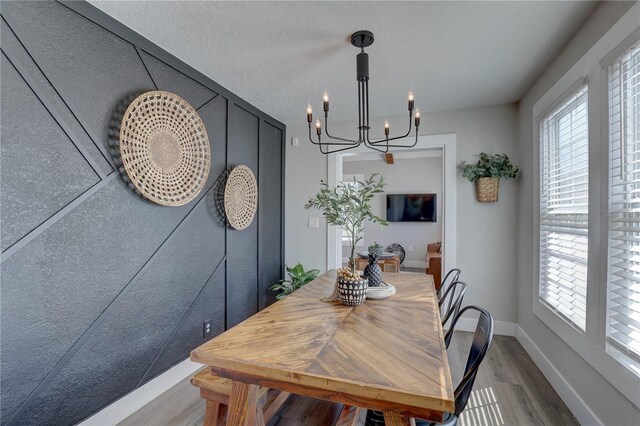 315 40th St S, Saint Petersburg, FL 33711 - dining area featuring a chandelier, a healthy amount of sunlight, baseboards, and wood finished floors