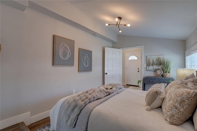 315 40th St S, Saint Petersburg, FL 33711 - bedroom with lofted ceiling, visible vents, an inviting chandelier, wood finished floors, and baseboards