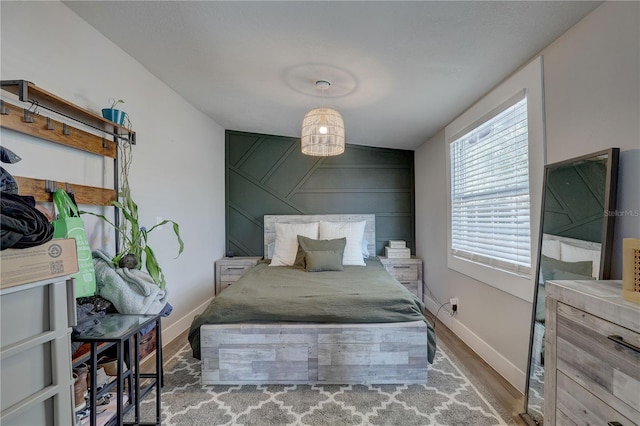 315 40th St S, Saint Petersburg, FL 33711 - bedroom featuring an accent wall, wood finished floors, and baseboards