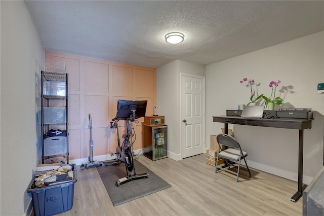 315 40th St S, Saint Petersburg, FL 33711 - exercise room featuring light wood finished floors, baseboards, and a textured ceiling