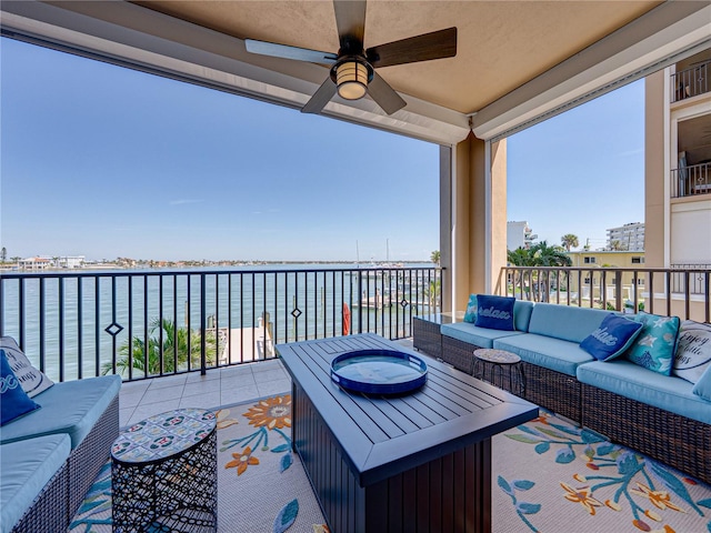 view of patio with a water view, ceiling fan, a balcony, and an outdoor hangout area