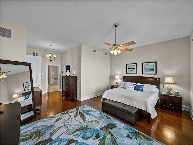 bedroom featuring a textured ceiling, hardwood / wood-style flooring, visible vents, and baseboards