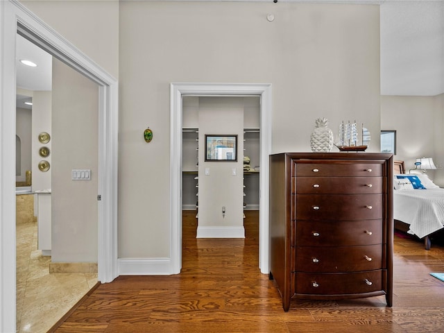 corridor featuring baseboards and wood finished floors