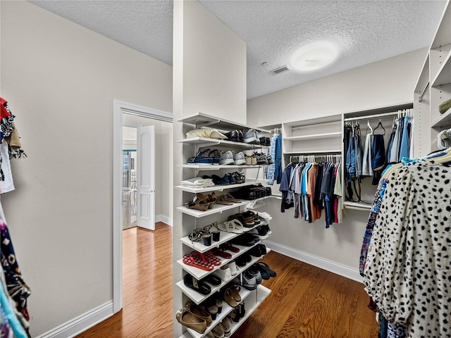 spacious closet featuring wood finished floors and visible vents