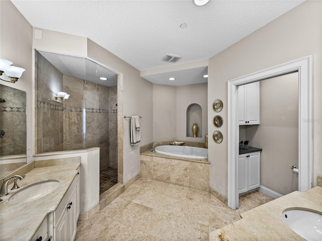 bathroom with two vanities, visible vents, a sink, and a walk in shower