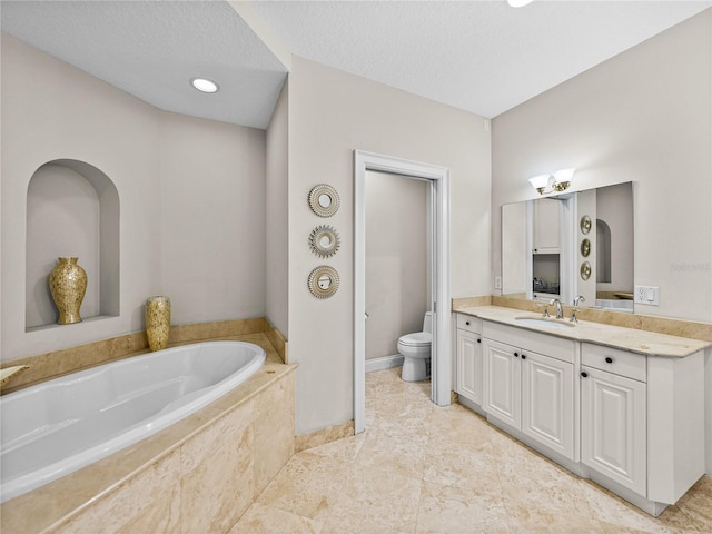 bathroom with a bath, a textured ceiling, vanity, and toilet