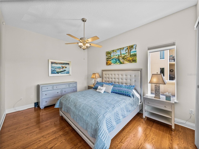 bedroom featuring ceiling fan, baseboards, and wood finished floors