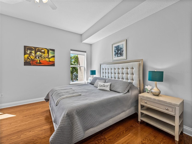 bedroom with a ceiling fan, baseboards, and wood finished floors