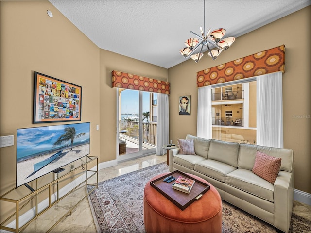 living room featuring a chandelier, marble finish floor, a textured ceiling, and baseboards