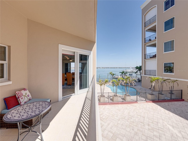 balcony featuring a patio area, a water view, and visible vents