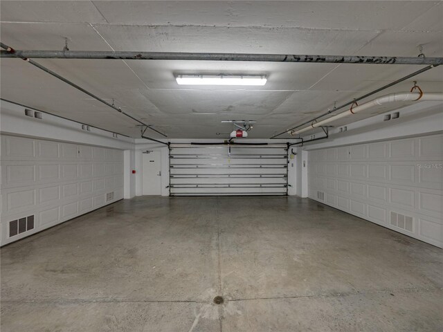 parking garage featuring visible vents and a garage door opener