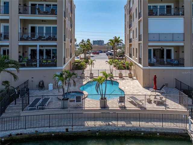 view of swimming pool with a patio area, fence, and a pool with connected hot tub