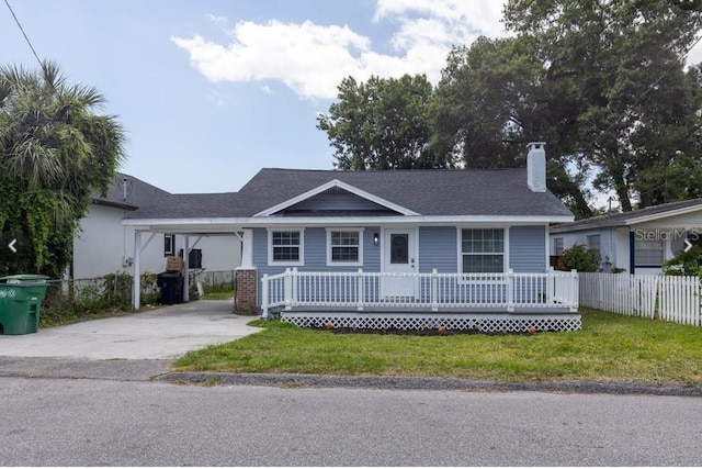 ranch-style home with driveway, a front lawn, a porch, fence, and a carport