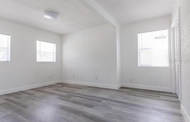 spare room with wood finished floors and baseboards