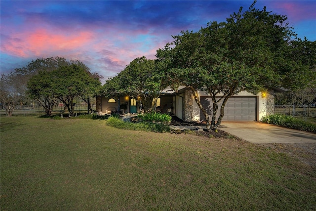 view of front facade featuring driveway, a lawn, and an attached garage