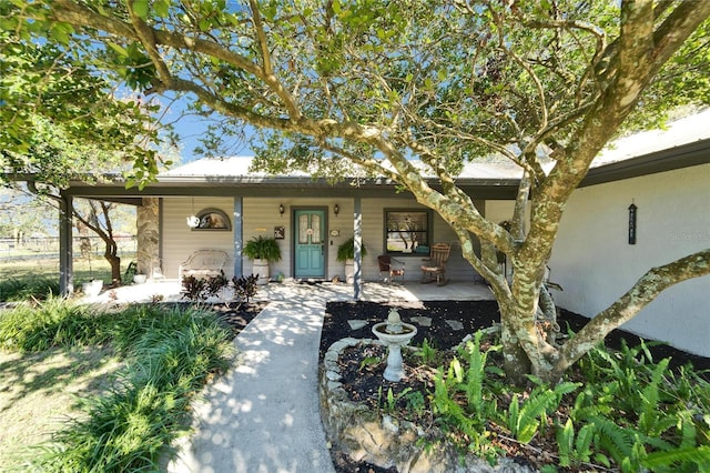 ranch-style home with a porch and stucco siding