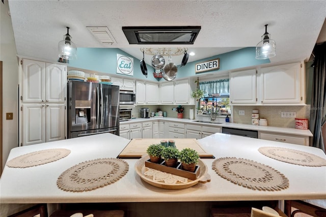 kitchen featuring stainless steel appliances, white cabinets, a sink, and a breakfast bar area