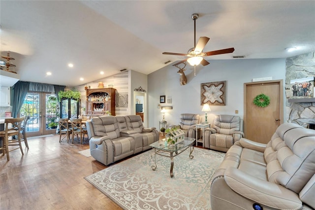 living room with light wood-style floors, lofted ceiling, french doors, and visible vents