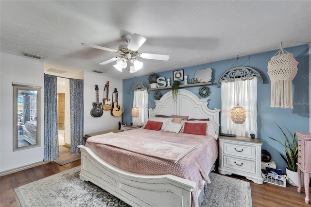 bedroom with multiple windows, ceiling fan, visible vents, and wood finished floors