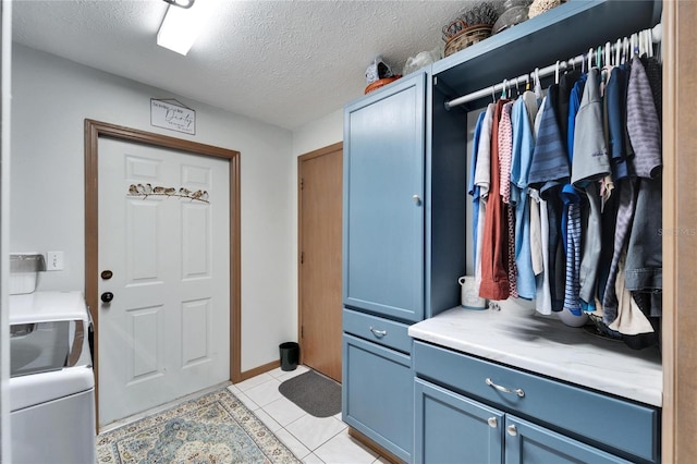 mudroom featuring light tile patterned floors and a textured ceiling