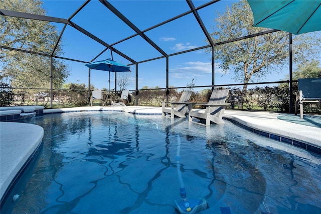 view of pool with a patio area, glass enclosure, and a pool with connected hot tub