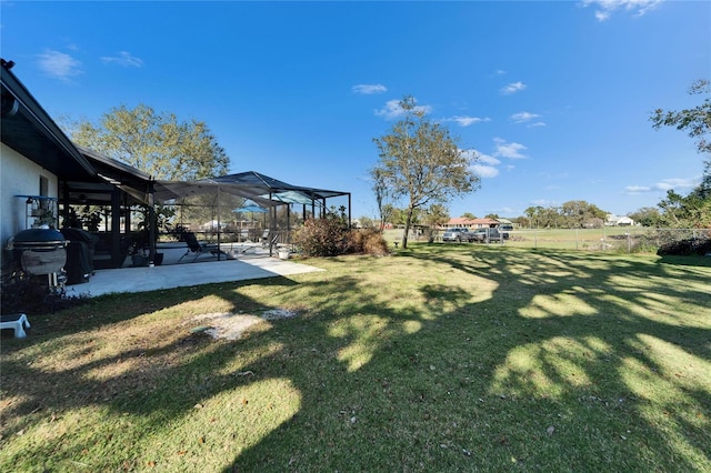 view of yard with a patio, fence, and glass enclosure