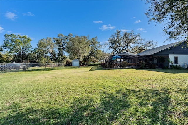 view of yard with an outbuilding, fence, and a storage shed