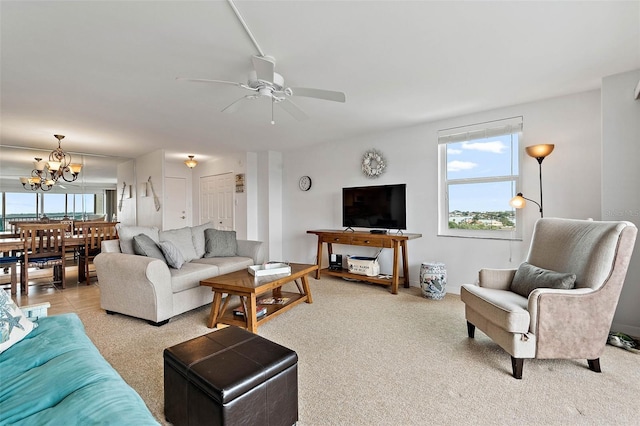 living room with ceiling fan with notable chandelier