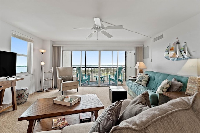 living room featuring a wealth of natural light, visible vents, and light carpet