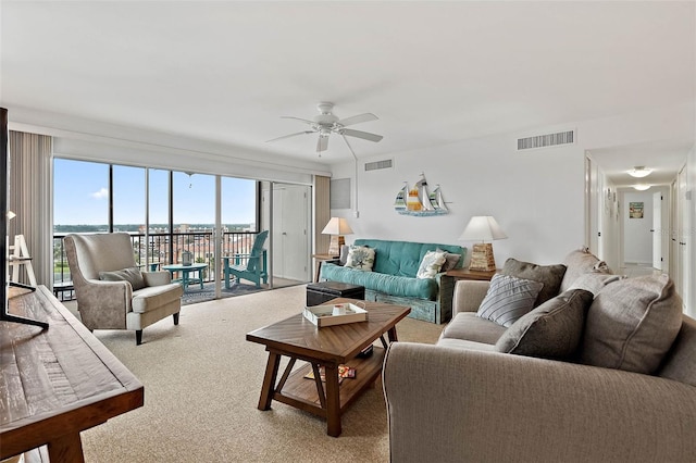 living room featuring carpet flooring, a ceiling fan, and visible vents