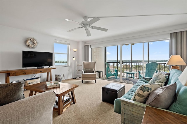 living room featuring carpet flooring, a healthy amount of sunlight, and ceiling fan