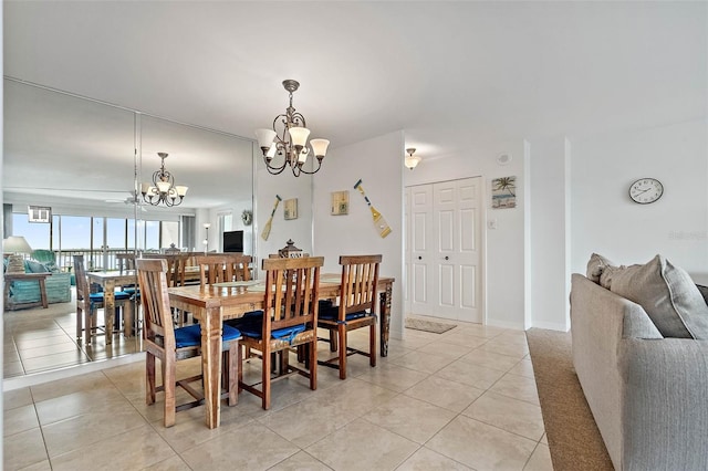 dining area featuring a chandelier, light tile patterned floors, and baseboards