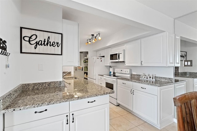 kitchen with white appliances, white cabinetry, and a sink