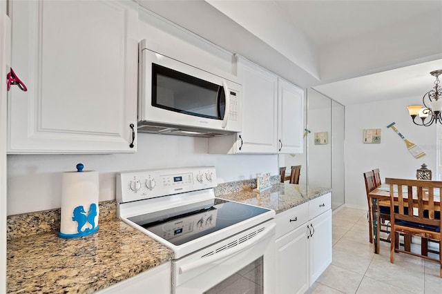 kitchen with white appliances, light stone countertops, light tile patterned flooring, white cabinetry, and a notable chandelier