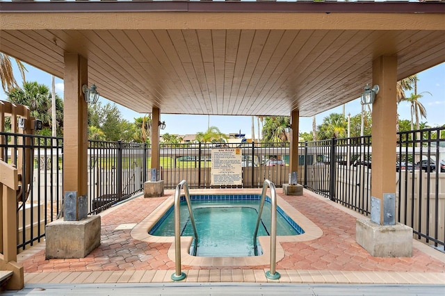 view of pool featuring a patio, fence, and a hot tub