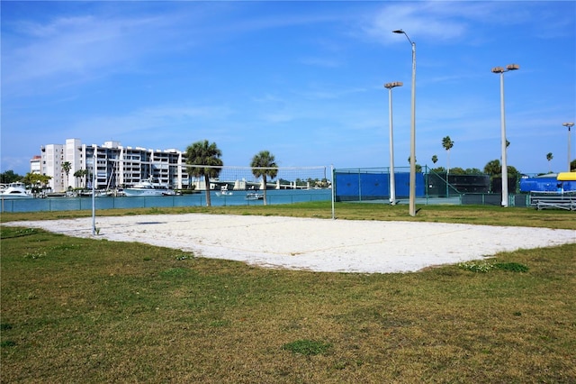 view of home's community with a water view, a lawn, and volleyball court