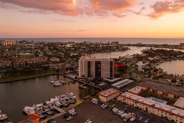 aerial view at dusk featuring a view of city and a water view