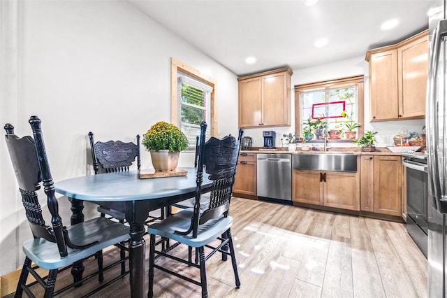 kitchen with light wood-style flooring, recessed lighting, a sink, light countertops, and appliances with stainless steel finishes