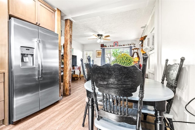 dining area with a textured ceiling, ceiling fan, a wall mounted air conditioner, and light wood-style flooring