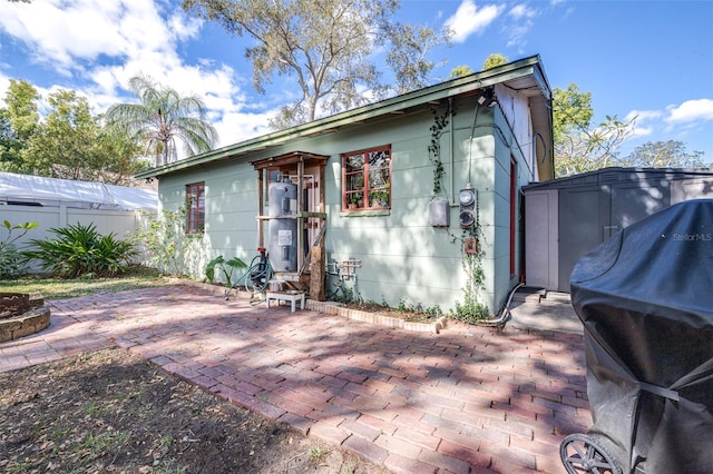 rear view of property with a patio area, a storage shed, fence, and an outbuilding