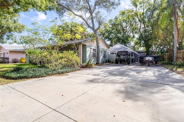 view of side of home with concrete driveway and fence