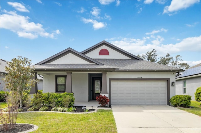 view of front of home featuring an attached garage, concrete driveway, roof with shingles, stucco siding, and a front yard