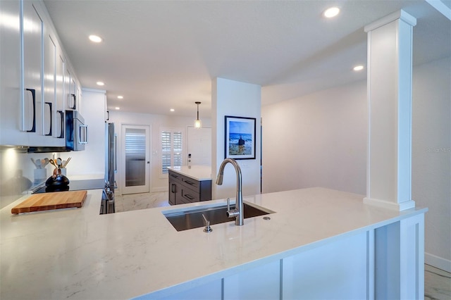 kitchen featuring recessed lighting, stainless steel appliances, a sink, white cabinetry, and marble finish floor