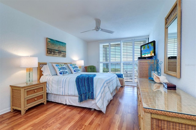 bedroom with light wood finished floors and a ceiling fan