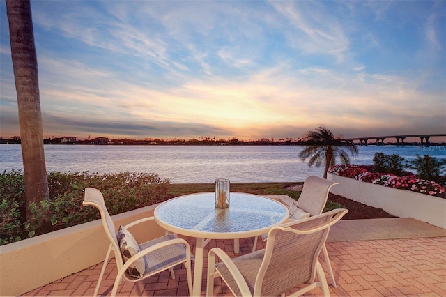 view of patio with outdoor dining area and a water view