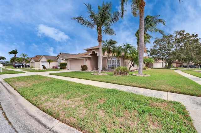 view of front of house featuring a garage, a front lawn, concrete driveway, and stucco siding